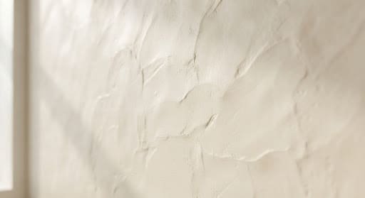 Hand-trowelled ivory microcement wall with soft surface ripples